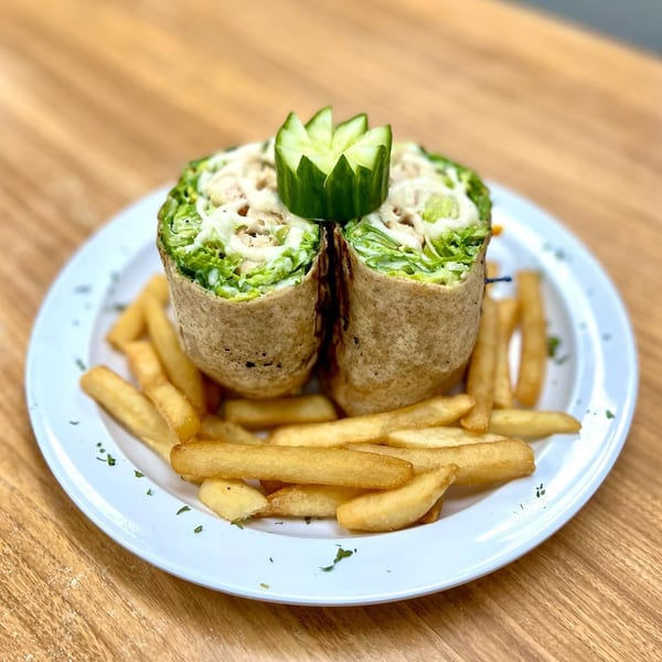Two Michigan Deli wraps filled with lettuce and sauce, garnished with cucumber, served with fries.